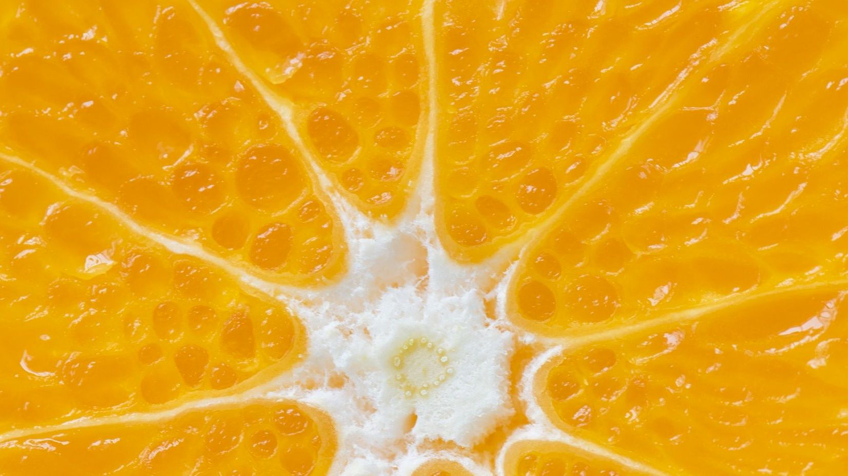 Close-up of orange fruit segments with juicy pulp and white pith, bright and fresh.